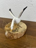 Front view of the wooden goose sculpture over nest with eggs mounted on a wood base