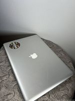 Closed silver aluminum MacBook Pro top view showing Apple logo and sticker on lid.