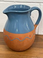 Front and side view of the blue glazed pottery jug showing the painted redware section and handle.