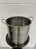 Front and side view of the stainless steel cookware pot showing exterior surface and one handle.