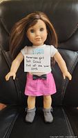 Front view of the American Girl Doll Grace holding a sign confirming it is the 2015 Doll of the Year.