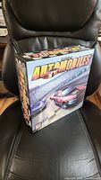 Box art with racing cars and title 'Automobiles' shown on the front of the box.
