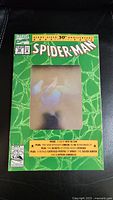 Front view of Spider-Man Issue #26 30th Anniversary comic book with holographic cover showing Spider-Man image under light.