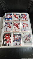 Page of nine hockey cards featuring players in red and white jerseys from the 1991 Upper Deck series, protected in plastic sleeves inside a binder.