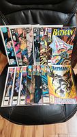 Full lot of 15 vintage Batman comic books displayed in protective sleeves showing colorful cover art.