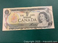 Front view of the 1973 Canadian one dollar bill showing Queen Elizabeth II and the Canadian coat of arms.