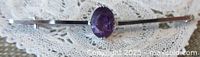 View of the full bar pin with oval amethyst center set in white gold
