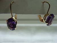 Front-side view showing oval amethyst stones set in gold with hook closures.