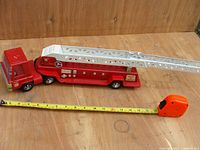 Overall side view of the fire engine with measuring tape showing approximately 17 inches length.
