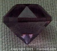 Top and side close-up views of a round, faceted purple amethyst loose stone on a beige textured fabric background.