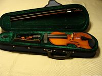 Full view of the 1/4 size violin with bow inside dark green velvet-lined case.