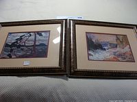 Two framed Group of 7 landscape prints side by side showing Canadian nature scenes.
