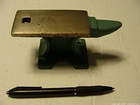 Small metal anvil with pen for size comparison