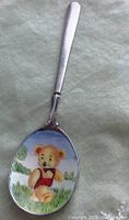 Photo of the spoon showing the colorful enamel baby bear on the bowl