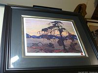 Framed print showing the full artwork of Tom Thomson's 'The Jack Pine' with dark wooden frame and grey mat.