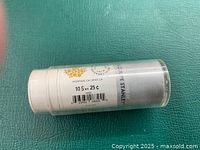 Side view of the sealed cylindrical roll with label indicating face value $10 in quarters by Royal Canadian Mint