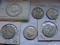 Six U.S. silver half dollar coins displayed together showing varying years and designs.