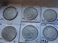 Six coins in cardboard flips: three Morgan dollars (1921) and three Peace dollars (1922, 1924, 1925)