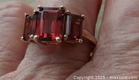 Top view on finger showing three prong-set emerald-cut stones