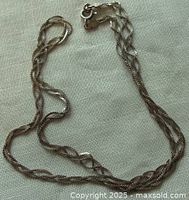 Full view of the vintage 18 inch sterling silver braided chain necklace laid flat showing the twisted braided pattern and the entire length