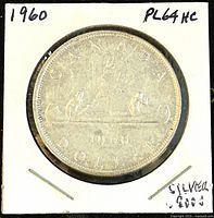 Reverse of 1960 Canadian silver dollar coin depicting two paddlers in a canoe with date 1960 and inscriptions.