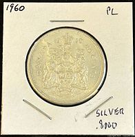 Obverse of 1960 Canadian 50 cents coin showing Canadian coat of arms with text '1960', 'CANADA', '50 CENTS', and silver content .8000 written on holder.
