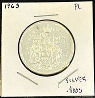 Reverse of 1963 Canadian silver 50 cents coin showing detailed crest with a lion and unicorn, inscriptions including 'CANADA' and '50 CENTS'.