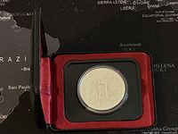 Closed red and black display case containing the silver coin.
