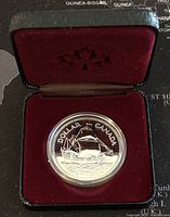 1979 Canadian silver dollar coin displayed in an open black case with burgundy velvet interior.
