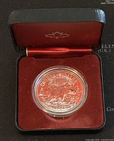 1980 Canadian silver dollar coin in its black case with red velvet interior and maple leaf emblem.