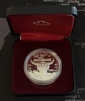 Coin displayed in black case with red velvet interior showing the reverse design.