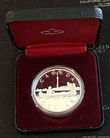 Canadian silver proof dollar coin in display case showing the reverse side depicting canoe with Toronto skyline and CN Tower