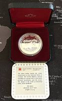 Photo of the silver proof coin in a red presentation case with Royal Canadian Mint logo interior lid.