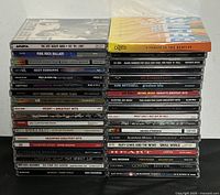 Front view of stacked CDs with visible spine titles of rock music albums.