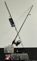 Full lot showing one fishing rod, two reels attached, and multiple plastic tackle boxes with assorted fishing lures.
