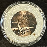 Obverse side of the silver plated medal showing a WWII bomber, explosions, and inscriptions pertaining to Operation Pointblank and the 75th Anniversary of D-Day.