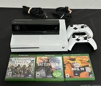 Overview of the Xbox One console, Kinect sensor, two wireless controllers, three game cases, and cables.