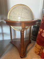 Full view of globe on wooden tripod stand
