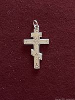 Front view of yellow gold triple-bar Orthodox cross pendant on burgundy background