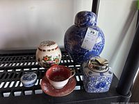 Photo showing the full set of three lidded ginger jars, the lidded trinket box, and Aynsley teacup with saucer.