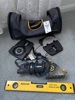 Photo showing Mastercraft precision saw, two shoe plates, laser level, and carrying bag spread on floor.