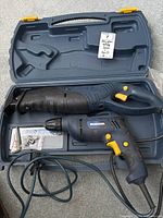 Open plastic carrying case with Mastercraft reciprocating saw and power drill inside, cords visible and small accessory bag included.