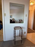 Photo showing the rectangular wall mirror mounted above the plant stand on a wall.