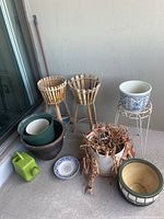 Wide shot of pots, stands, plastic plants, and watering can.