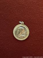 Front view of the religious pendant with a relief image of a woman