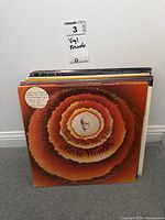 Stack of vinyl records with Stevie Wonder's 'Songs in the Key of Life' album cover visible on top.