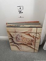 Floor display of vinyl records showing spine edges and full Chicago album cover with leather jacket design.