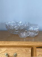 Photo showing the large Mikasa centerpiece bowl, the small crystal bowl, and the cream and sugar set placed on a wooden surface against a plain background.