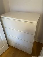 Photo of the retro white low boy dresser showing the front and side angles.