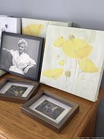Set of 8 wall decor pieces on a wooden surface including floral canvas prints, vintage framed photo, small framed bird prints, and a vintage-style wine sign.